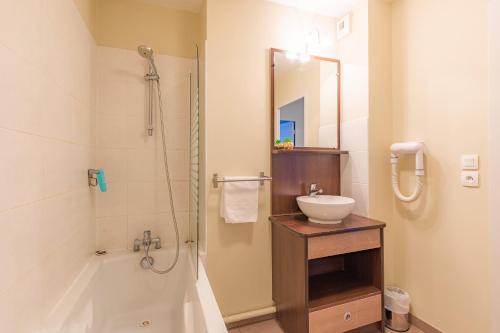 a bathroom with a shower and a sink and a tub at Appart'City Classic La Roche sur Yon Centre in La Roche-sur-Yon