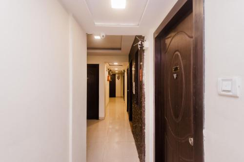 a hallway leading to a room with a door at Hotel Phoenix in Mumbai