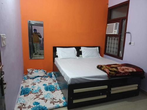 a bedroom with a bed and a person taking a picture at OYO White Rock Hotel in Alwar