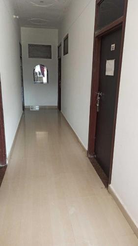 an empty room with a wooden floor and a door at OYO White Rock Hotel in Alwar