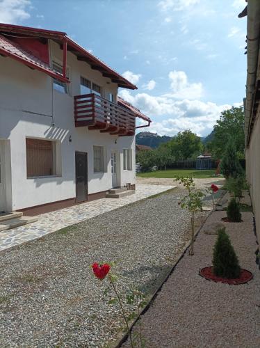 una casa con un vialetto di ghiaia accanto a un edificio di Casa OALPEM a Rîşnov