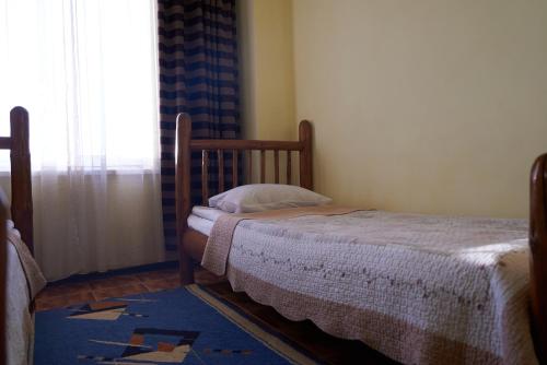 a small bed in a room with a window at Argo Guest House in Karakol