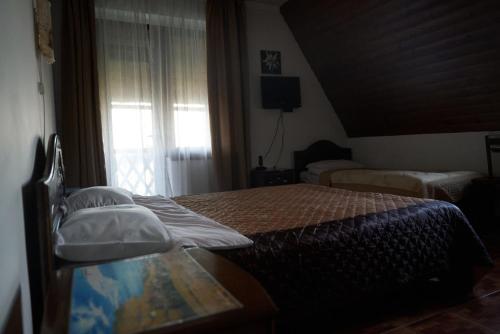 a bedroom with two beds and a window at Argo Guest House in Karakol