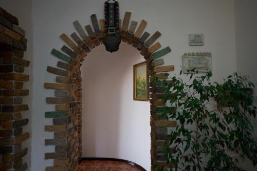 a brick archway in a room with a plant at Argo Guest House in Karakol