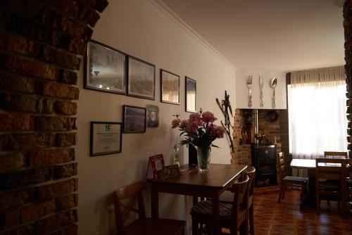 a dining room with a table with a vase of flowers at Argo Guest House in Karakol