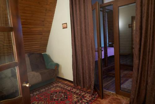 a living room with a chair and a mirror at Argo Guest House in Karakol
