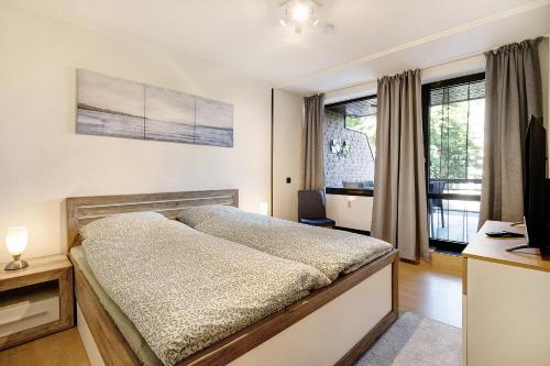 una camera da letto con un letto, una scrivania e finestre di Ferienwohnung Maja am Yachthafen a Bad Zwischenahn