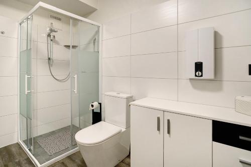 een witte badkamer met een toilet en een douche bij Ferienwohnung Maja am Yachthafen in Bad Zwischenahn