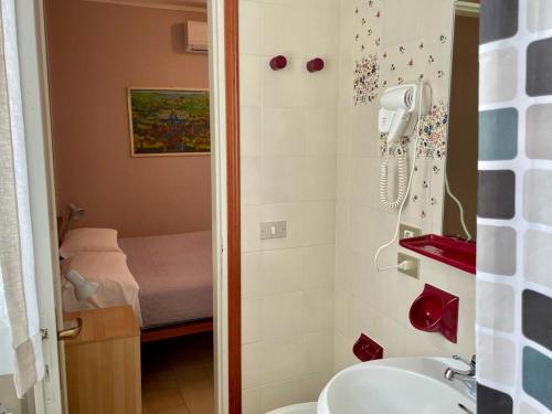 baño con lavabo y ducha con cama en Albergo Tecla en Lazise