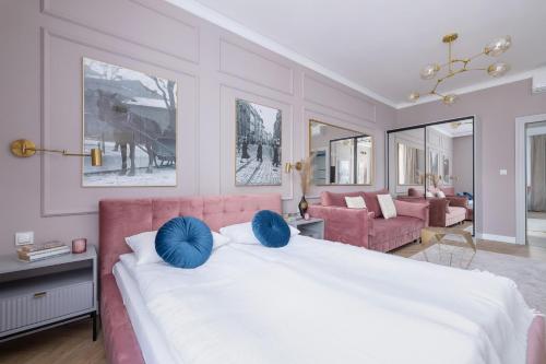 a bedroom with a large white bed with blue pillows at Starowiślna Elegant Apartment with Air Conditioning Kazimierz Cracow by Renters Prestige in Krakow