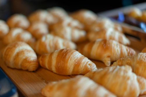 a bunch of croissants on a wooden cutting board at KING's Hotel First in Munich