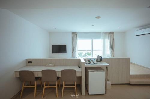 a kitchen with a table and chairs in a room at Worita Cove Hotel in Na Jomtien