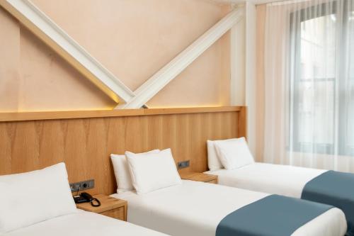 a room with two beds and a window at Premist Hotels Taksim in Istanbul
