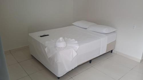 a white bed with a flower on it in a room at Pousada Sophia Beach in Salinópolis