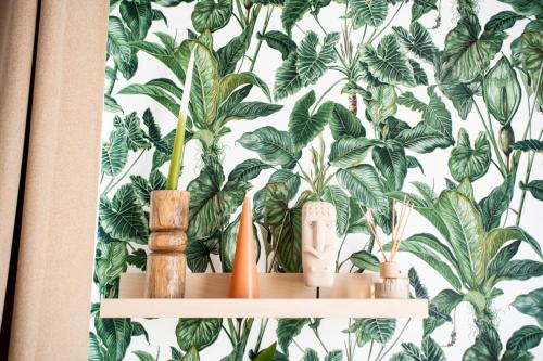 a shelf with plants on a wall with a wallpaper at LA CASITA in Alassio