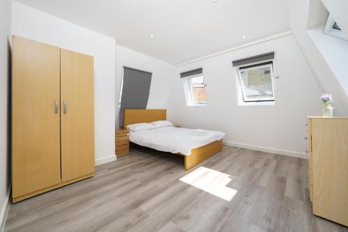 een kleine slaapkamer met een bed en een kast bij Modern Apartment in South West London in Londen