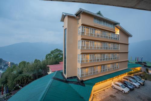 budynek z samochodami zaparkowanymi na parkingu w obiekcie Summit Namnang Courtyard & Spa w mieście Gangtok