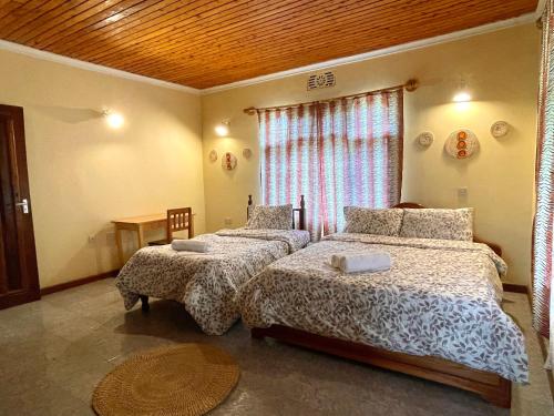 a bedroom with two beds and a window at Toiwo Residence Arusha in Arusha