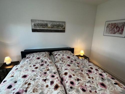 a bedroom with a bed with a floral bedspread at Ferienwohnung Lüttje Glück in Böxlund