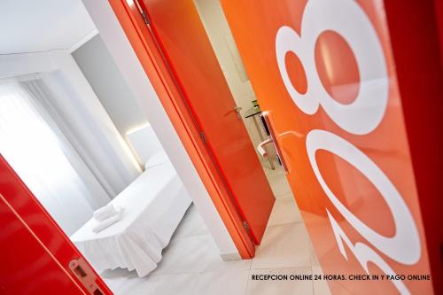 una habitación con una puerta roja y blanca y una cama en Hotel DL Port, en Castellón de la Plana