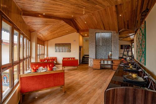a large living room with wooden ceilings and wooden floors at Summit Namnang Courtyard & Spa Near Mg Marg in Gangtok