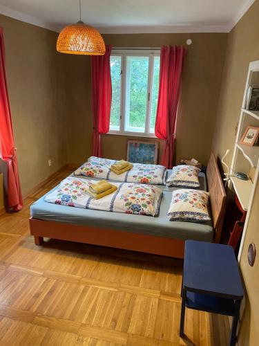 a bedroom with a bed and a window with red curtains at Hlinená izba na Hájiku in Banská Štiavnica