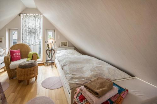 a bedroom with a bed and a chair in a attic at Die Kleine Oase 3 im Wohnhaus in Stuhr