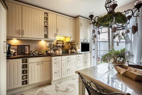 a kitchen with white cabinets and a table at Die Kleine Oase 3 im Wohnhaus in Stuhr