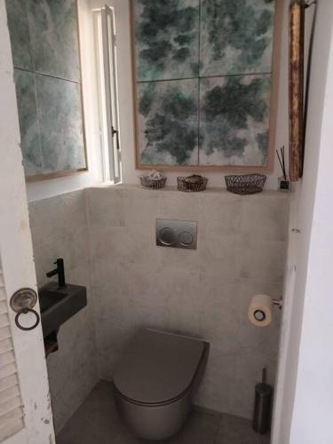 a bathroom with a toilet and a sink and a window at Studio avec roof top, vue d'exception, 5mn mer. in Tel Aviv