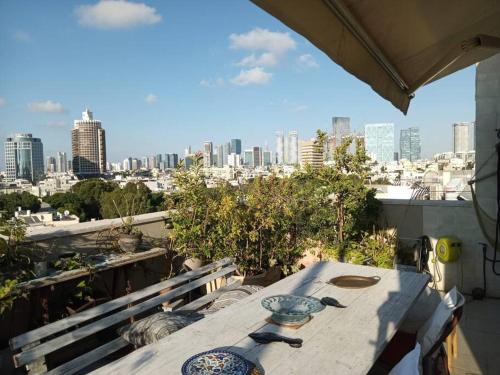 una mesa en un balcón con vistas a la ciudad en Studio avec roof top, vue d'exception, 5mn mer., en Tel Aviv