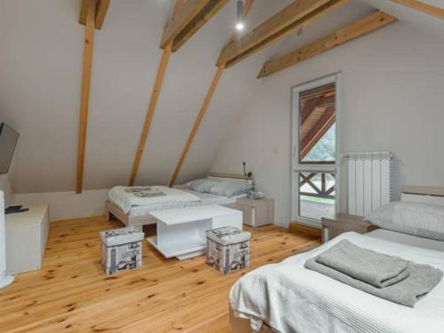 um quarto com duas camas e uma mesa em Domki nad Dunajcem em Tylmanowa