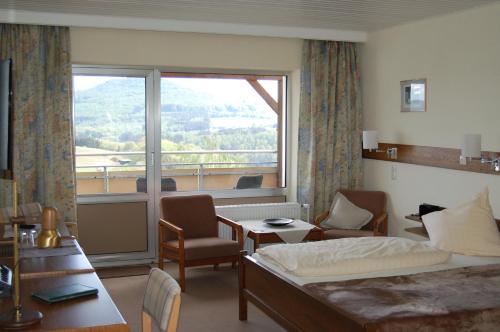 a hotel room with a bed and a large window at Landgasthaus Pfahl in Wershofen
