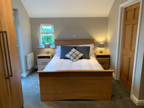 een slaapkamer met een bed met 2 nachtkastjes en 2 lampen bij Stella Maris in Kircubbin