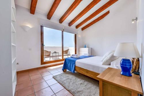 ein Schlafzimmer mit einem Bett und einem großen Fenster in der Unterkunft Villa Rocalla in Moraira