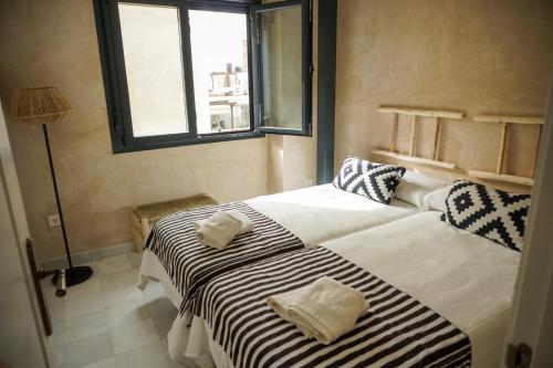 a bedroom with two beds with towels on them at Cathedral Sevilla Views in Seville