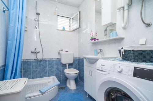 ein Badezimmer mit einer Waschmaschine und einem Waschbecken in der Unterkunft House Planika in Slano