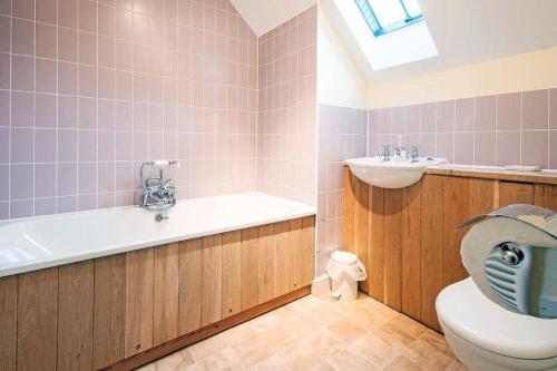 a bathroom with a toilet and a tub and a sink at Mill Village 75, Tide Cottage - P in Somerford Keynes