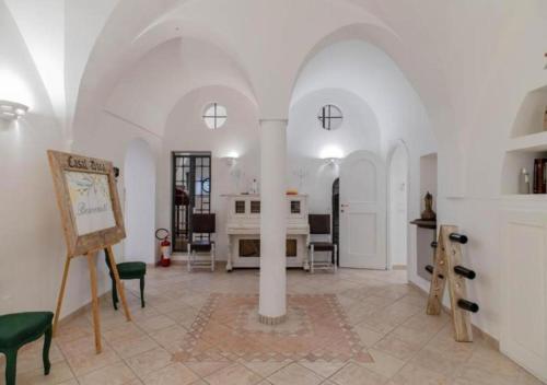 a large room with white walls and a table and chairs at Casal Duca in Taranto
