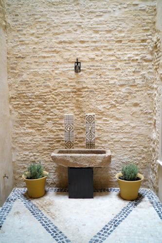 a bathroom with a sink and two potted plants at Cathedral Sevilla Views in Seville
