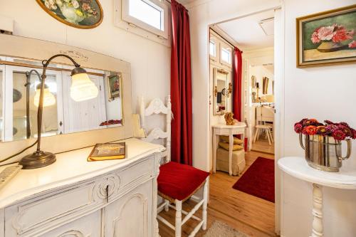 a room with a vanity with a mirror and a red chair at Die Kleine Oase in Stuhr