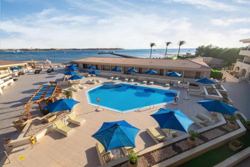- une vue sur la piscine dotée de parasols bleus dans l'établissement Cleopatra Luxury Resort Makadi Bay (Adults Only), à Hurghada