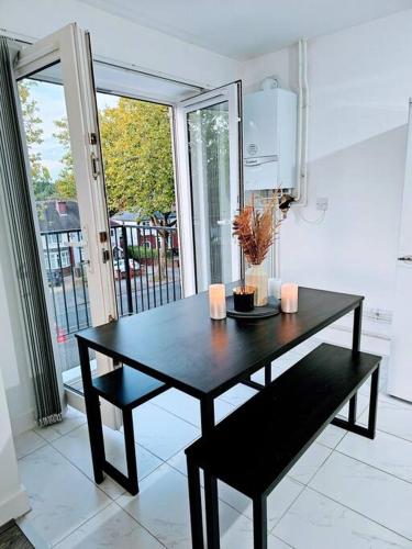een zwarte tafel met twee kaarsen in de keuken bij Swanky 1-Bedroom Apt in Walsall in Bescot