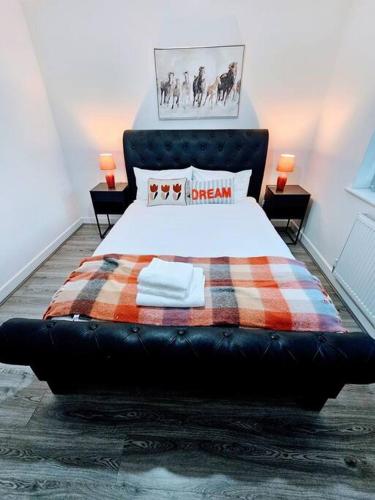 a bedroom with a large bed with a plaid blanket at Swanky 1-Bedroom Apt in Walsall in Bescot