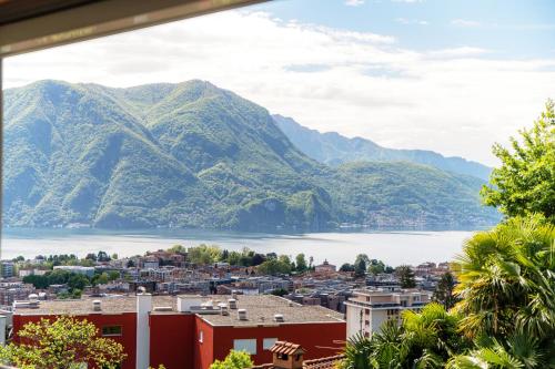 a view of a city with mountains in the background at Miravalle Lakeview by Quokka 360 - large windows and magical views in Massagno