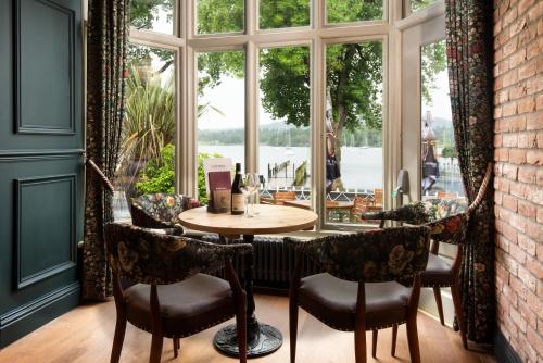 uma mesa e cadeiras num quarto com uma janela em The Waterhead Inn- The Inn Collection Group em Ambleside