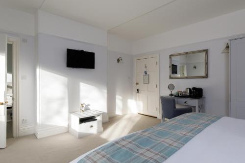a white bedroom with a bed and a sink at 4 Canon Lane in Chichester