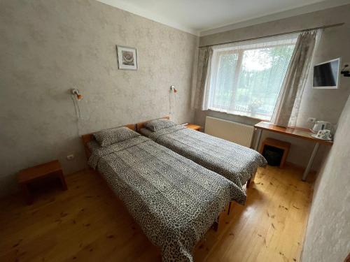 a bedroom with two beds and a window at Parks Guest House in Sigulda