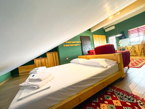 a large bed in a room with green walls at Cozy Elegance Above Korca in Korçë