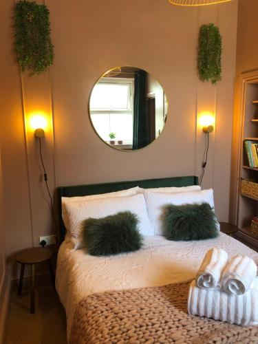 - une chambre avec un lit avec deux oreillers et un miroir dans l'établissement Ffau Bach - Little Den, à Pembroke Dock