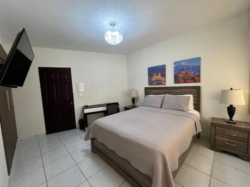 a bedroom with a bed and a flat screen tv at Hotel Casa Pamplona in San Salvador
